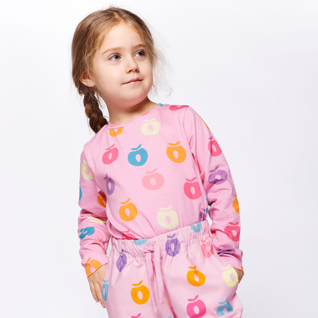 Pige med lyserød sweater og æble motiver